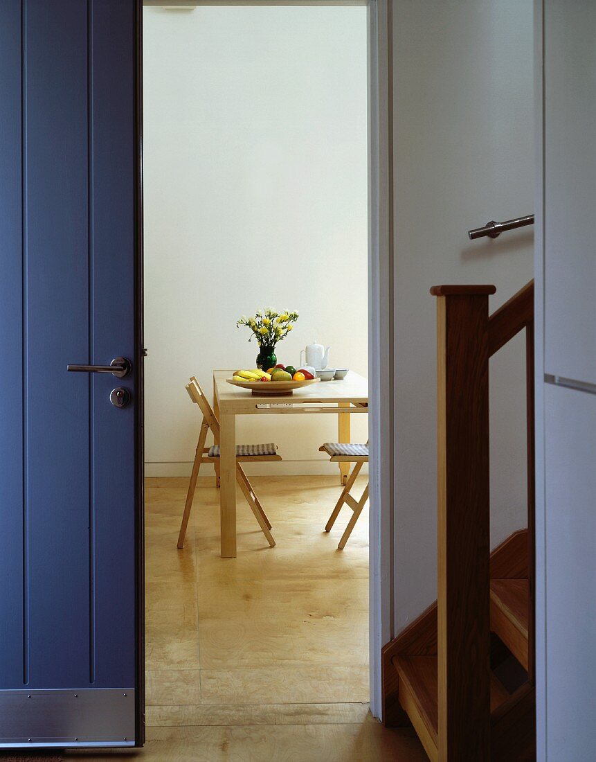 Front door and open doorway with view of dining table