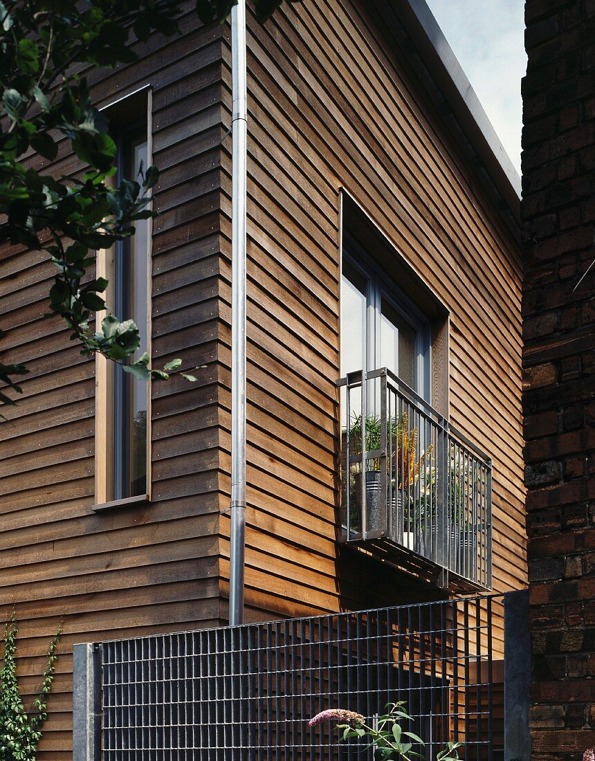 Modern, wooden house with metal balcony