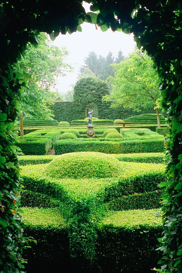 View through opening in hedge of gardens with topiary hedges, an example of landscape gardening