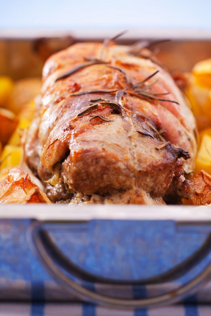 Turkey roulade with rosemary, vegetables and fruit in a roasting tin