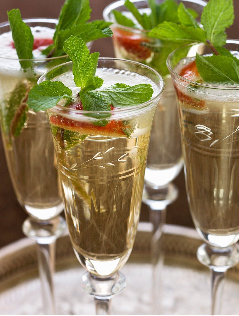 Champagner in Gläsern mit Erdbeere & frischer Minze