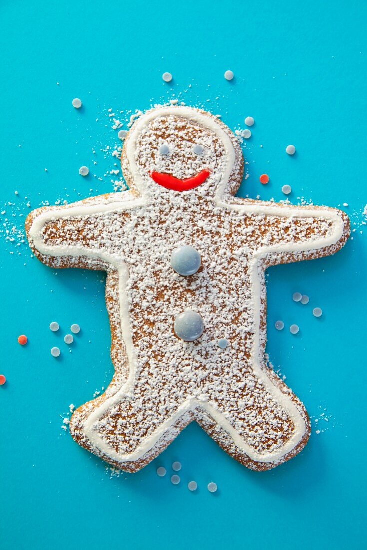 A gingerbread man decorated with chocolate beans and icing sugar