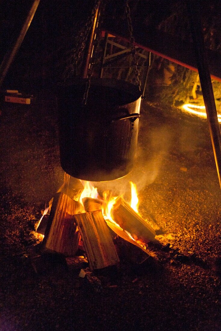 Mulled wine warming over bonfire