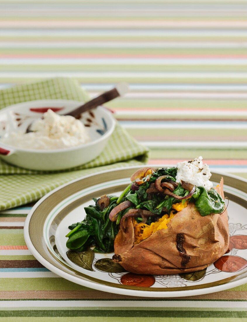 Baked sweet potato with feta, spinach and red onions