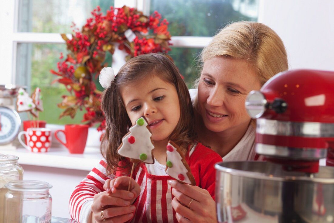 Mutter und Tochter betrachten Weihnachtsplätzchen in der Küche