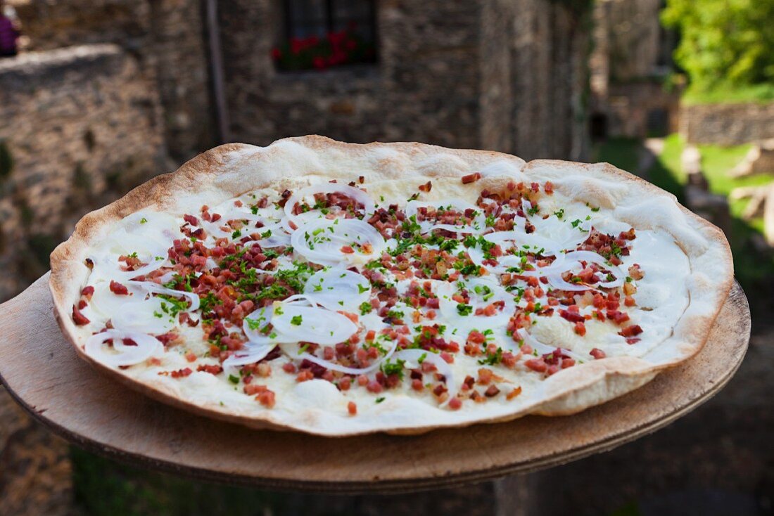 Tarte flambée topped with bacon and onions