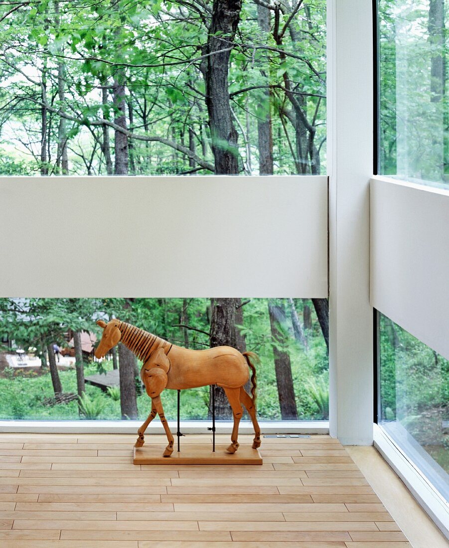 Pferdeskulptur auf dem Boden vor dem Fenster