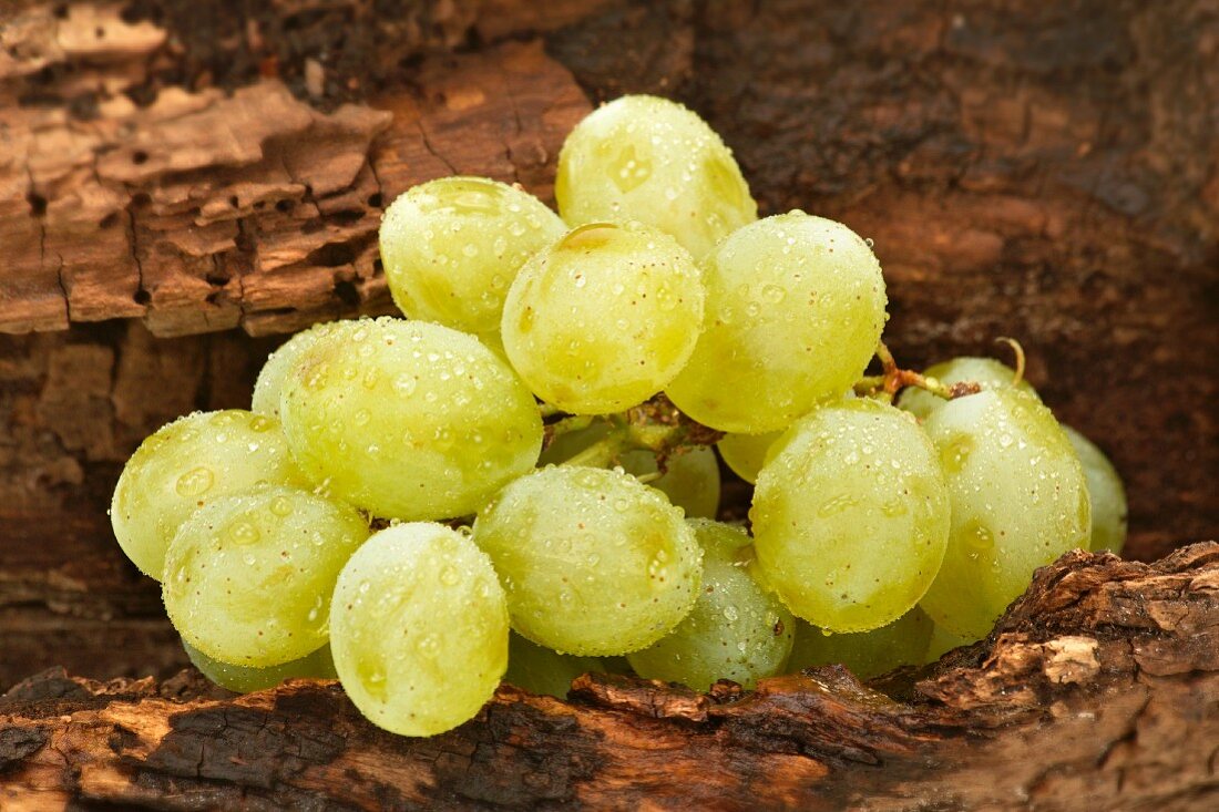 Freshly washed green grapes on a wooden surface