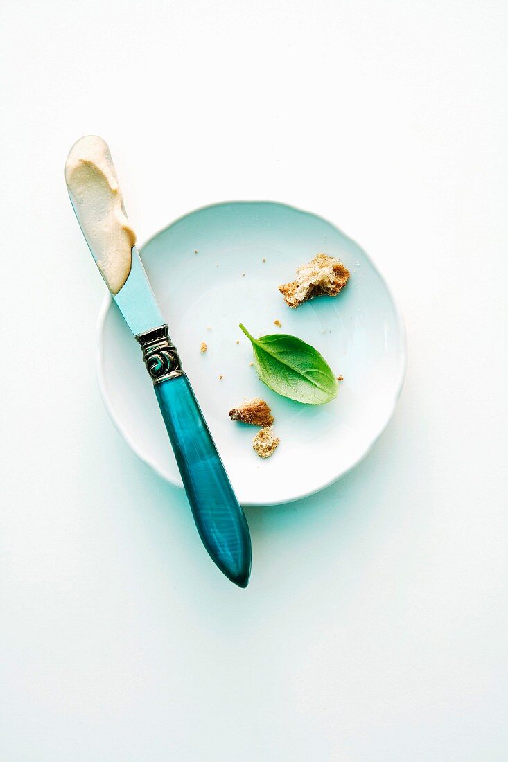 Food scraps on a plate with a knife