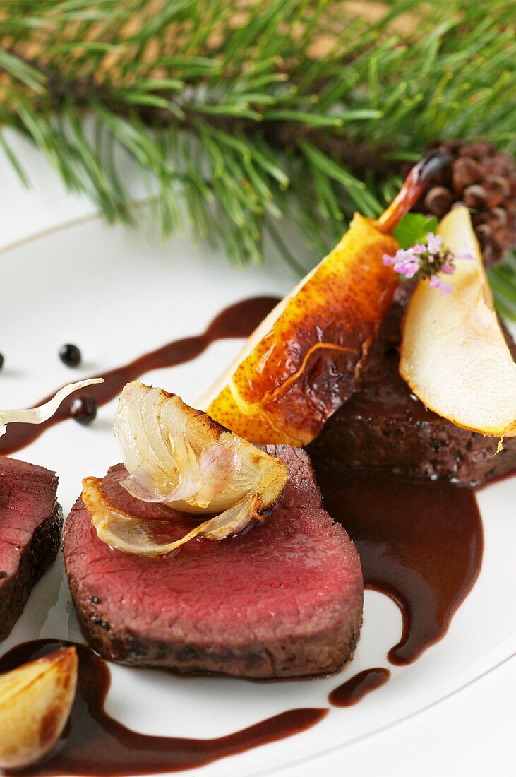 Roast saddle of venison with braised pears