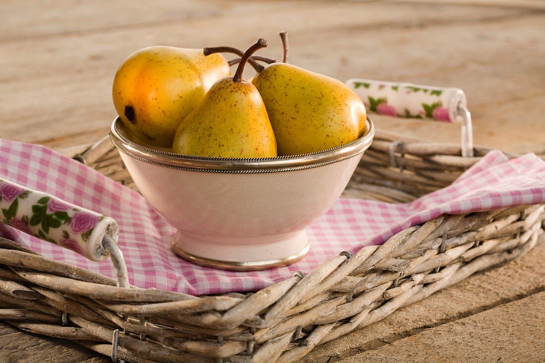 Pears in a ceramic bowl on a tray