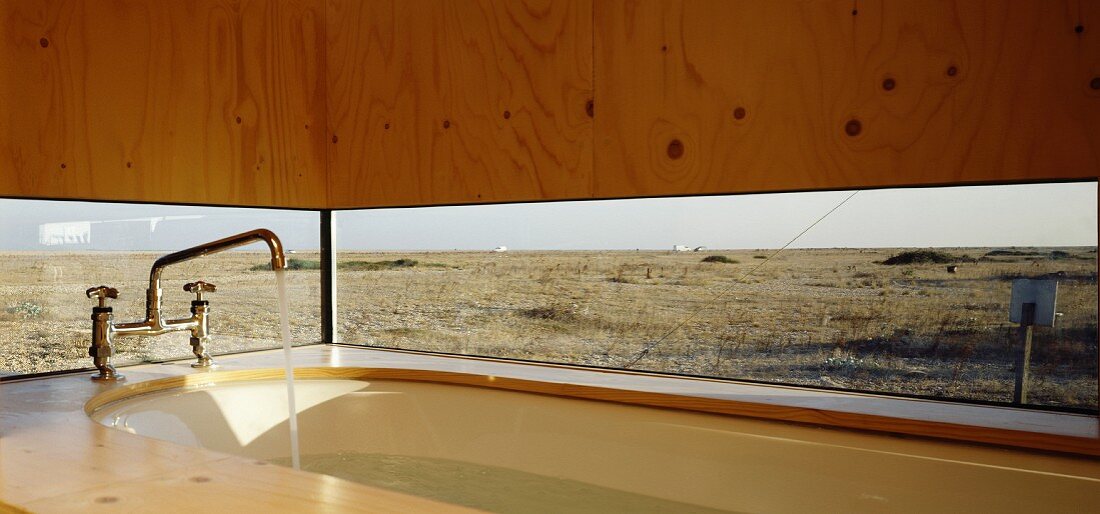 Bathtub next to panoramic window