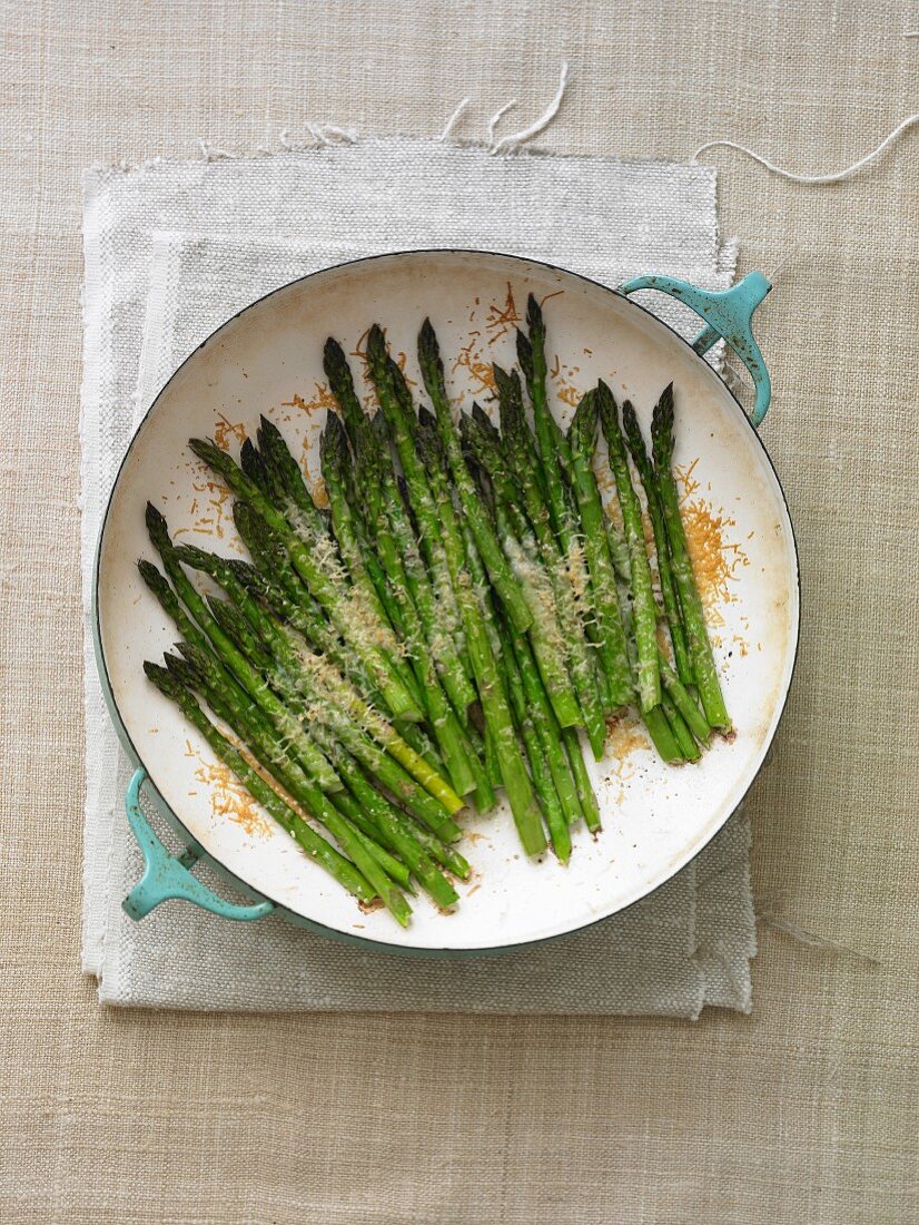 Grüner Spargel mit Parmesan in Pfanne (Draufsicht)