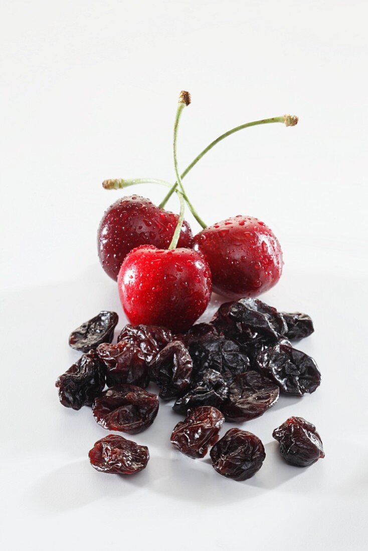 Small Wooden Bowl of Dried Cherries with a Fresh Cherry