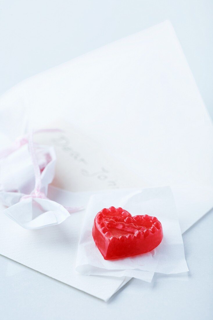 Liebesbotschaft: Briefumschlag mit Bonbon in Herzform