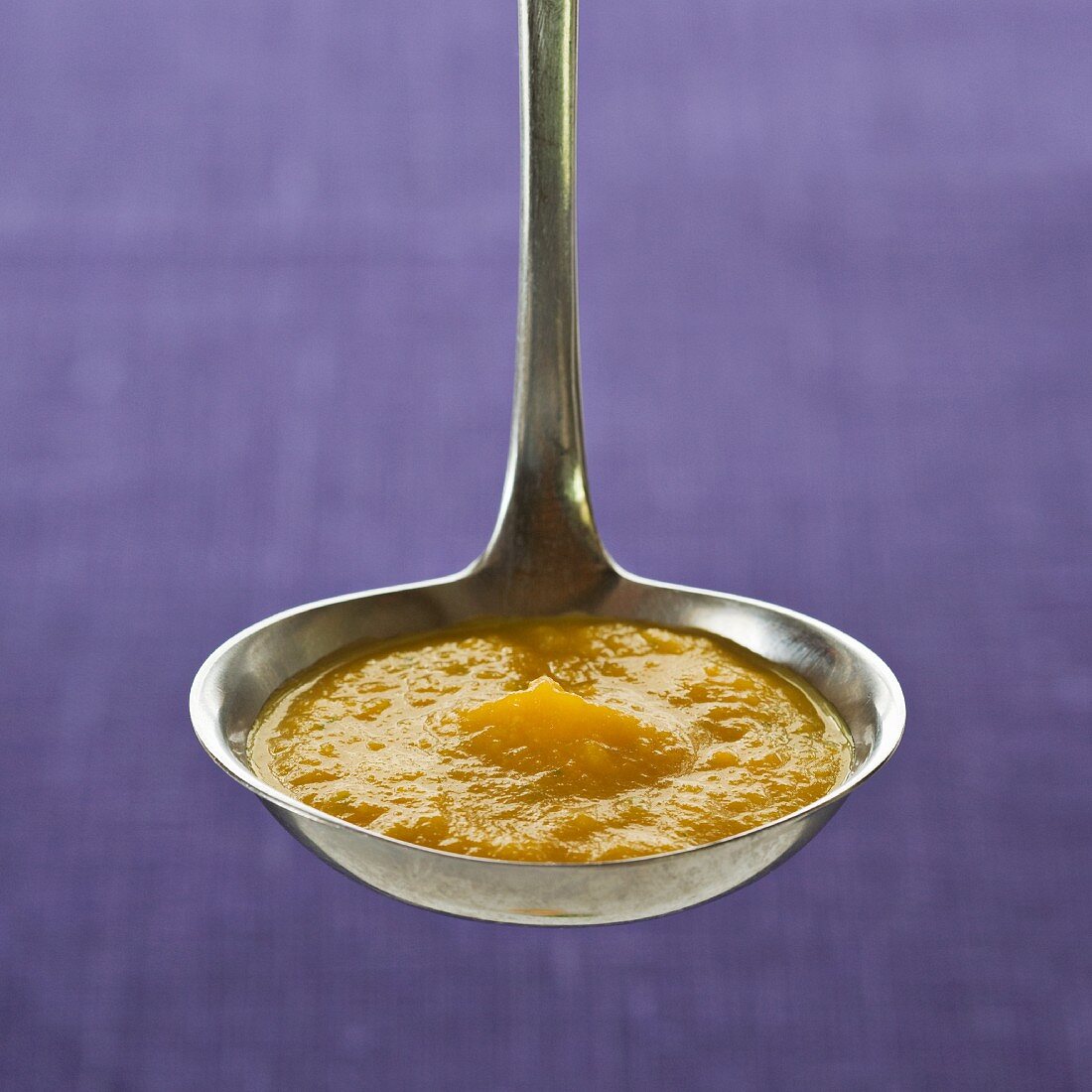 Ladle of carrot and orange sauce