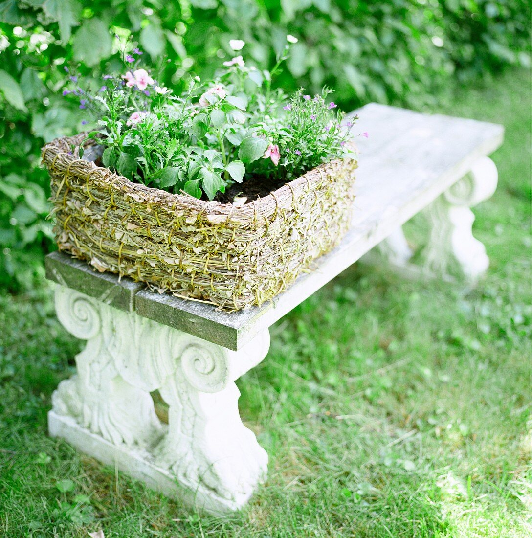 Basket of plants on Greek-style, antique stone bench