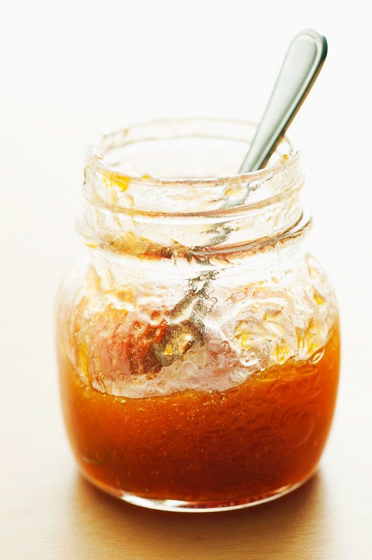 Spoon In a Half Empty Jar of Apricot Preserves