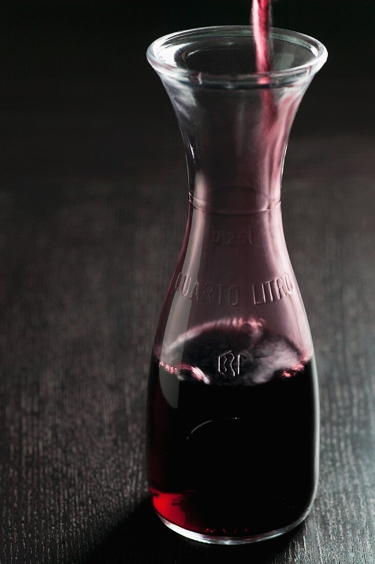 Red Wine Pouring into a Half Carafe