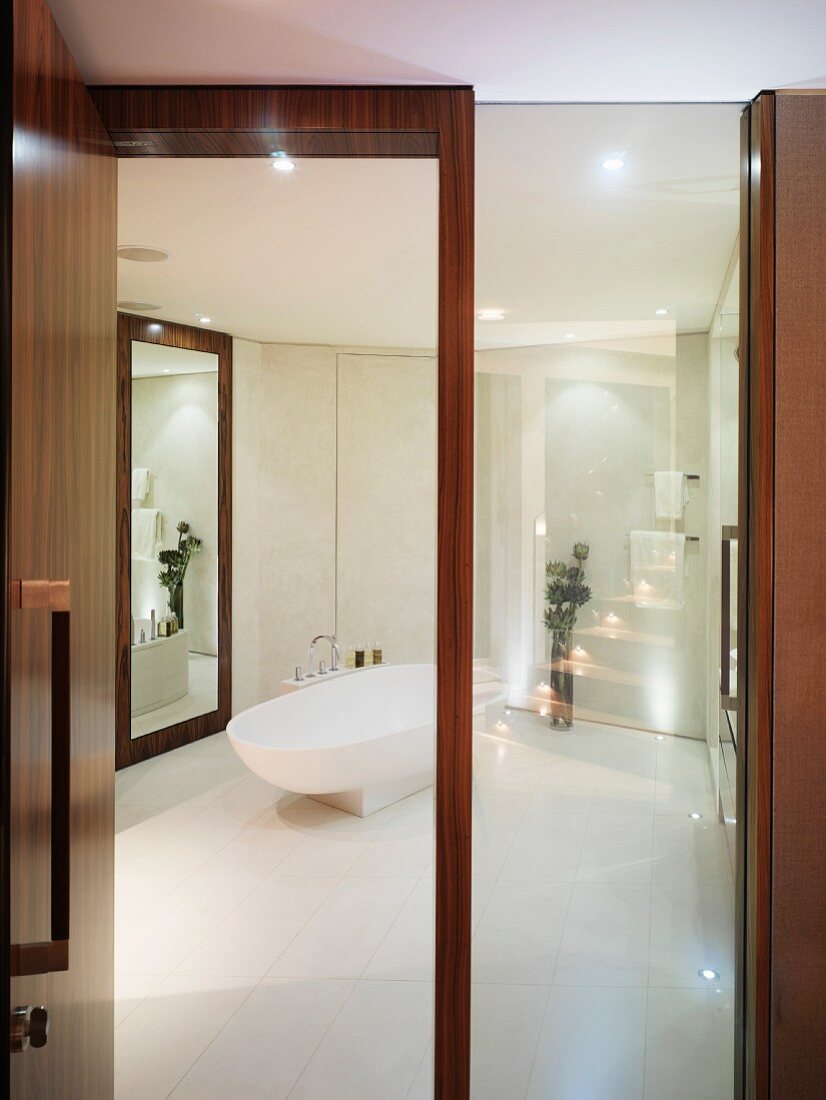 View through open wood and glass door into white designer bathroom