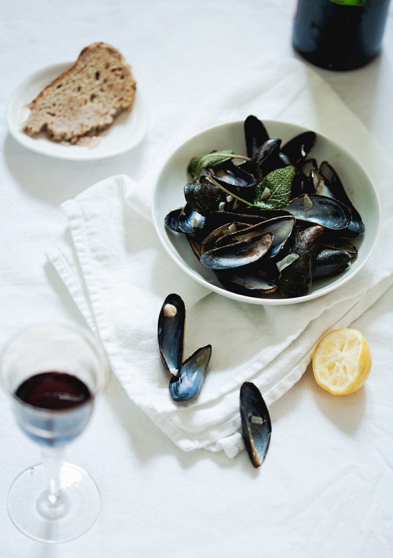 Leere Miesmuschelschalen, Zitrone, Brot und Rotwein