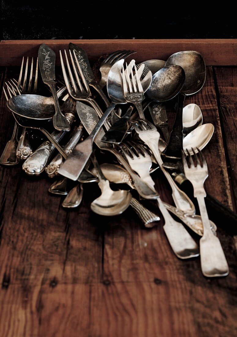 Assorted flatware on a wooden background