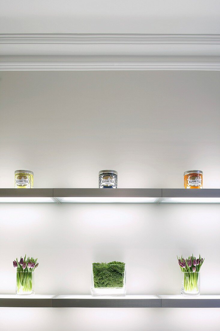 Illuminated glass shelving decorated with pretty preserves jars and flowers