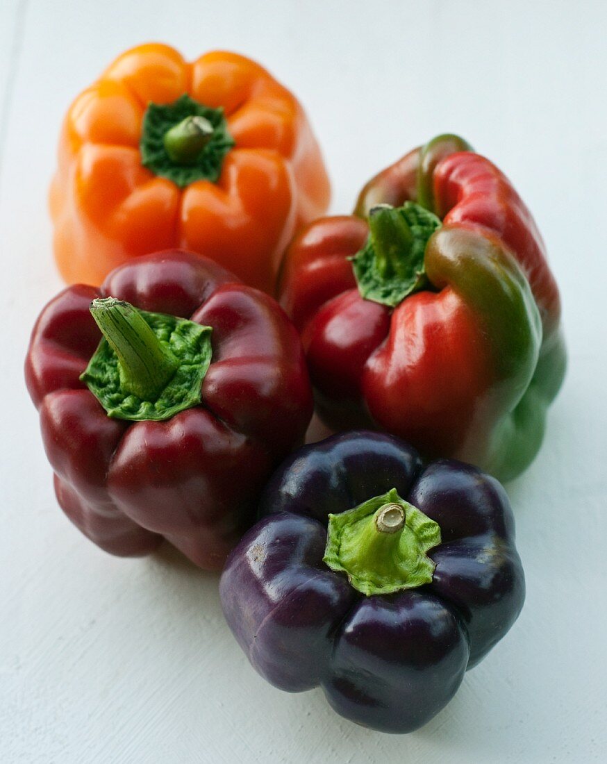Four peppers (rot, orange, purple)