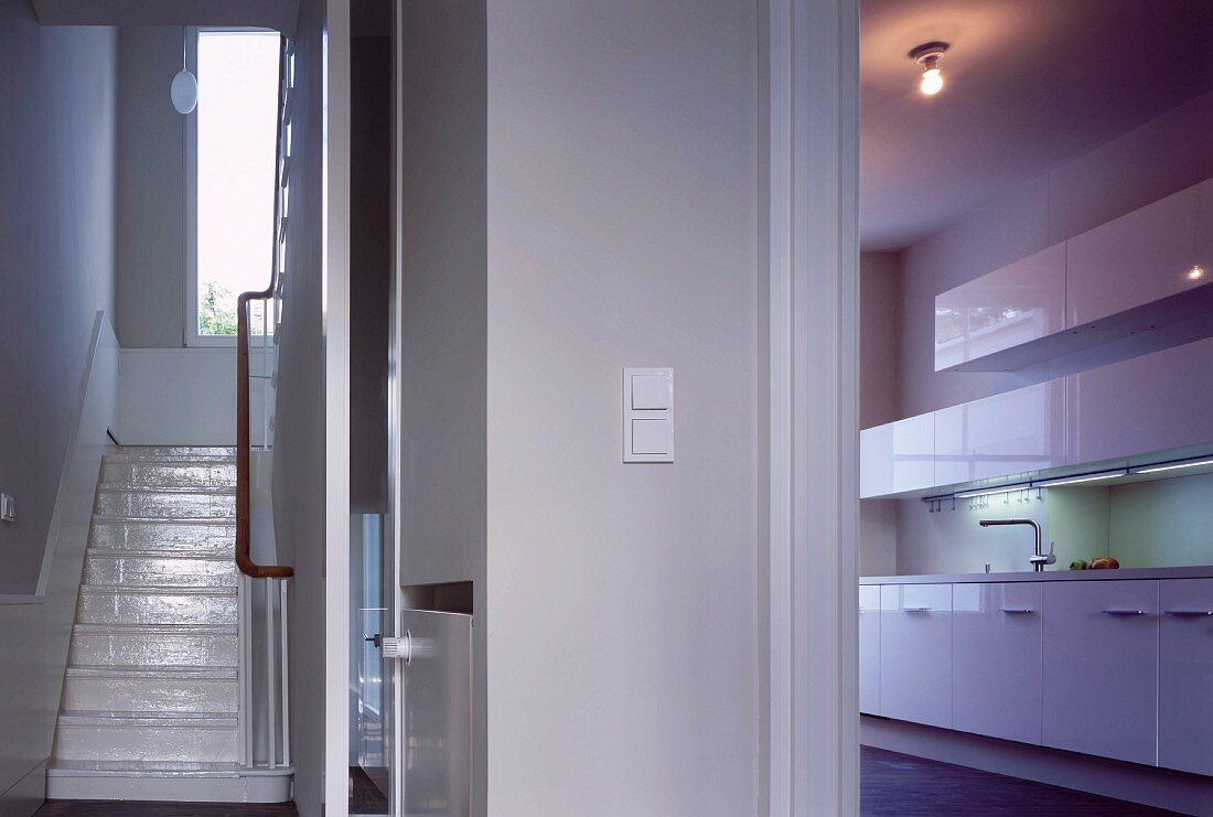 Foyer with view of stairs and view of kitchen through open door