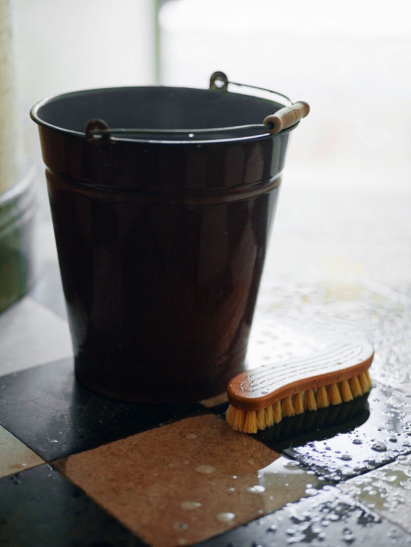 Black metal bucket and scrubbing brush