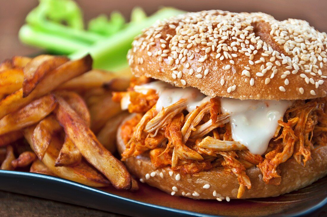 Shredded Buffalo Chicken Sandwich on a Sesame Seed Roll with French Fries