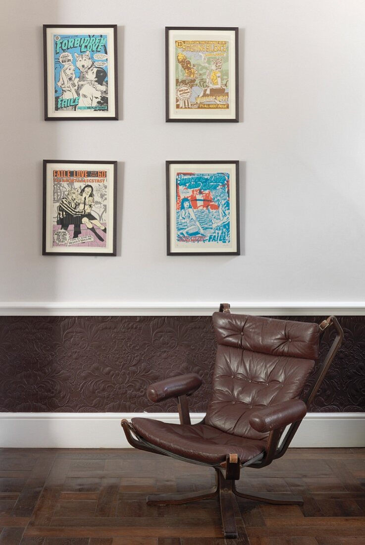 Old swivel chair with brown leather upholstery against wall with framed pictures
