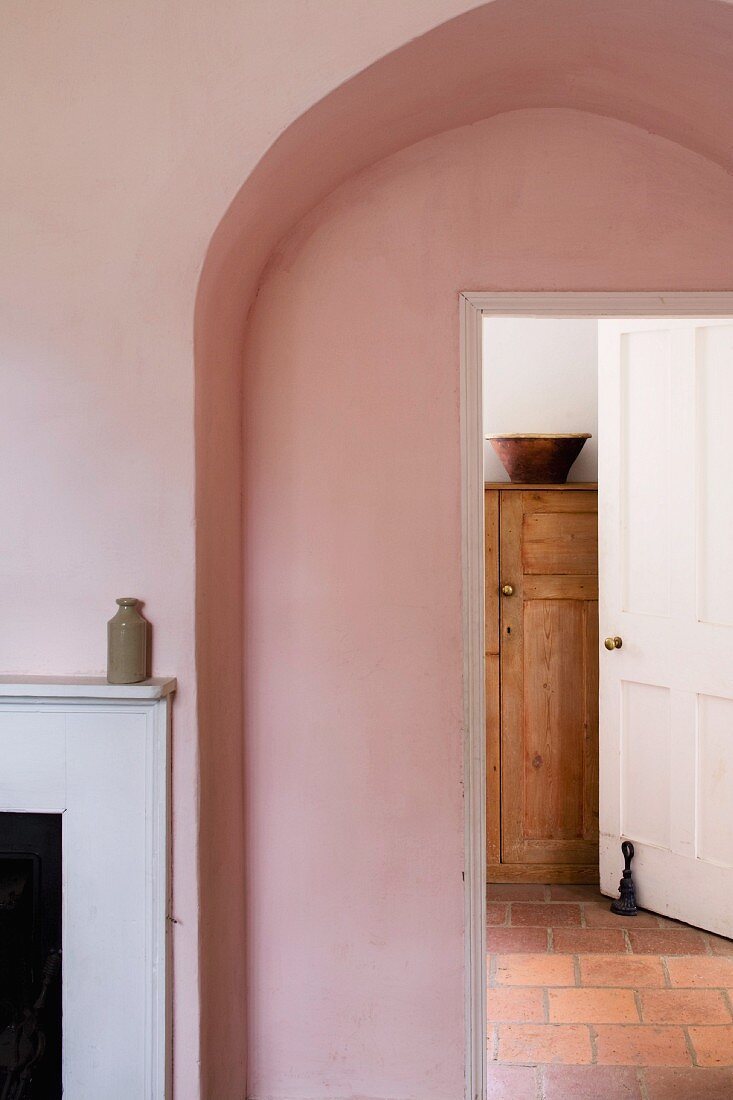 Simple arch with view of cupboard through integrated, open door