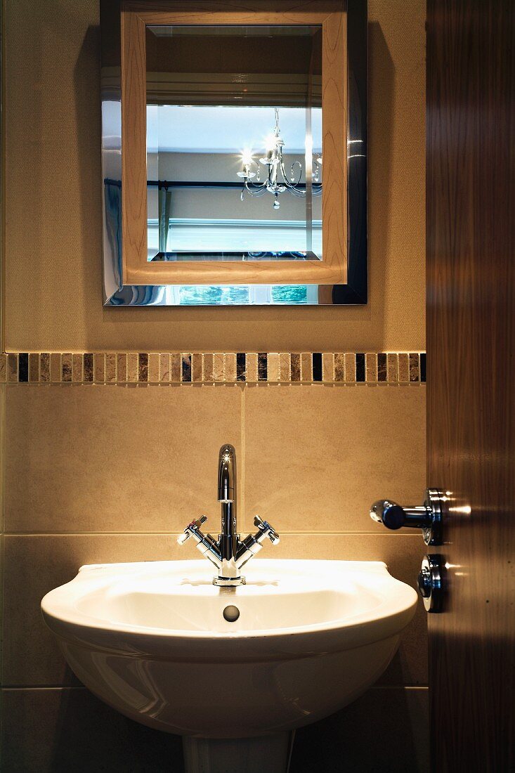 View of sink and mirror through open door