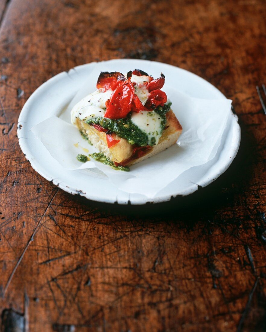 Bread topped with pesto, mozzarella and tomatoes