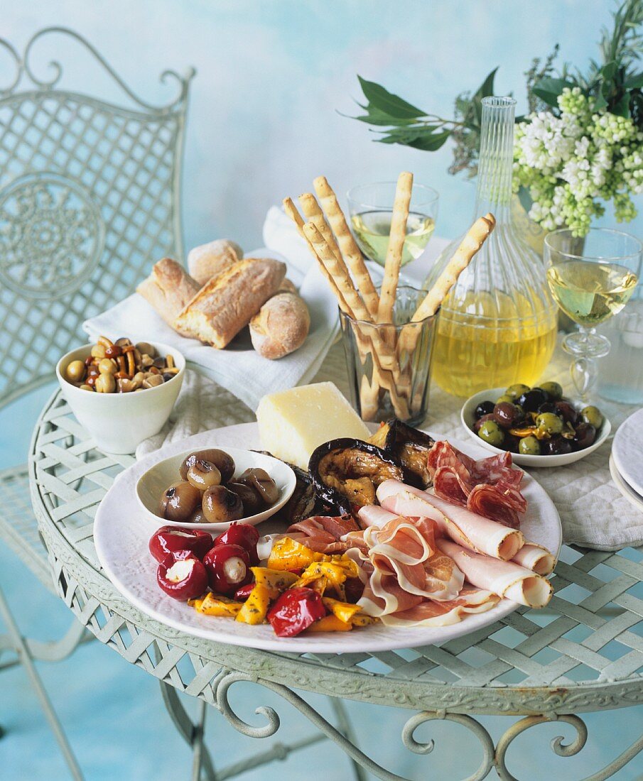 An antipasti platter with ham, preserved vegetables and cheese