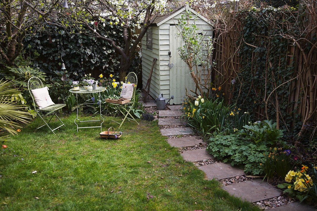 Garden table with two chairs next to shed