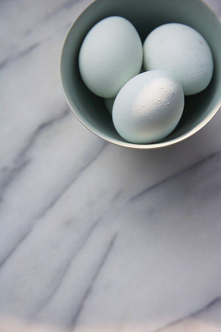 Three white eggs in a bowl
