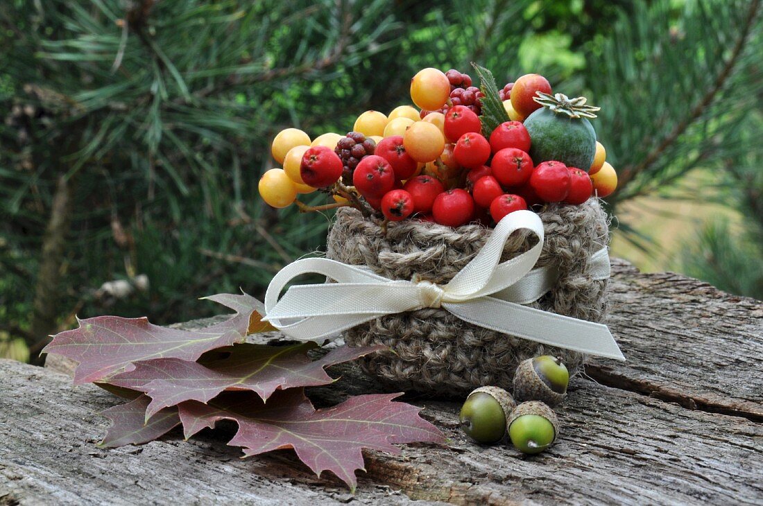 Autumnal arrangement with berries, crab apples, leaves & acorns