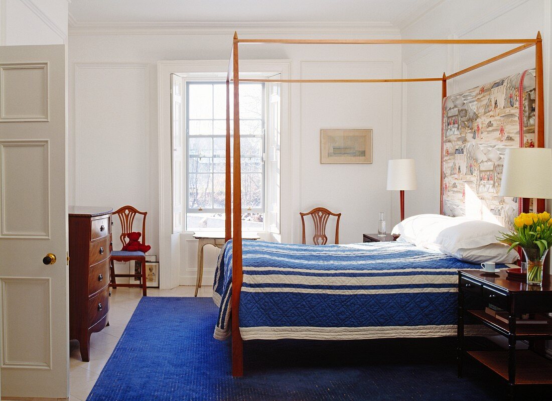 Bedroom with canopied bed, blue bedspread & blue rug