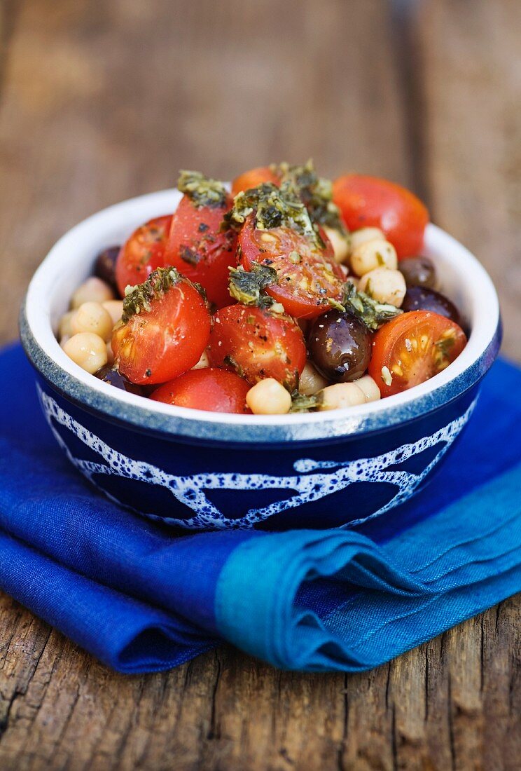 Tomato salad with chickpeas, black olives and pesto dressing