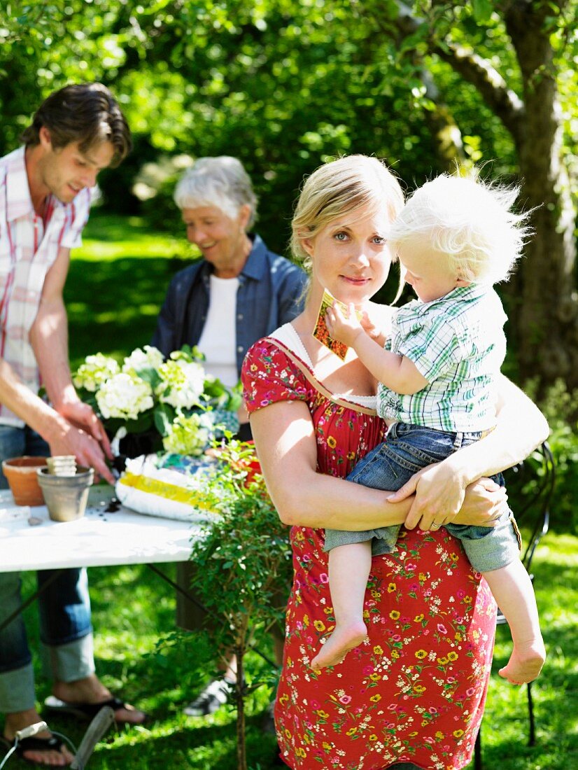 Junge Familie mit Großmutter im Garten