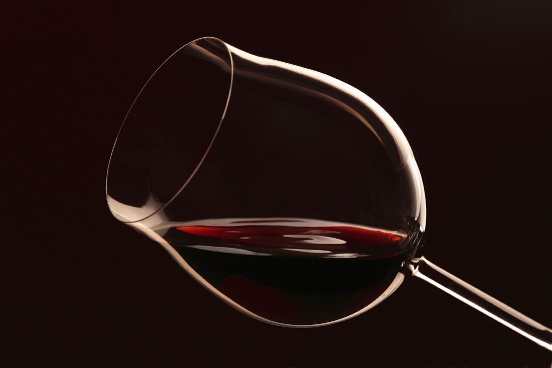 Ein Glas Rotwein vor schwarzem Hintergrund