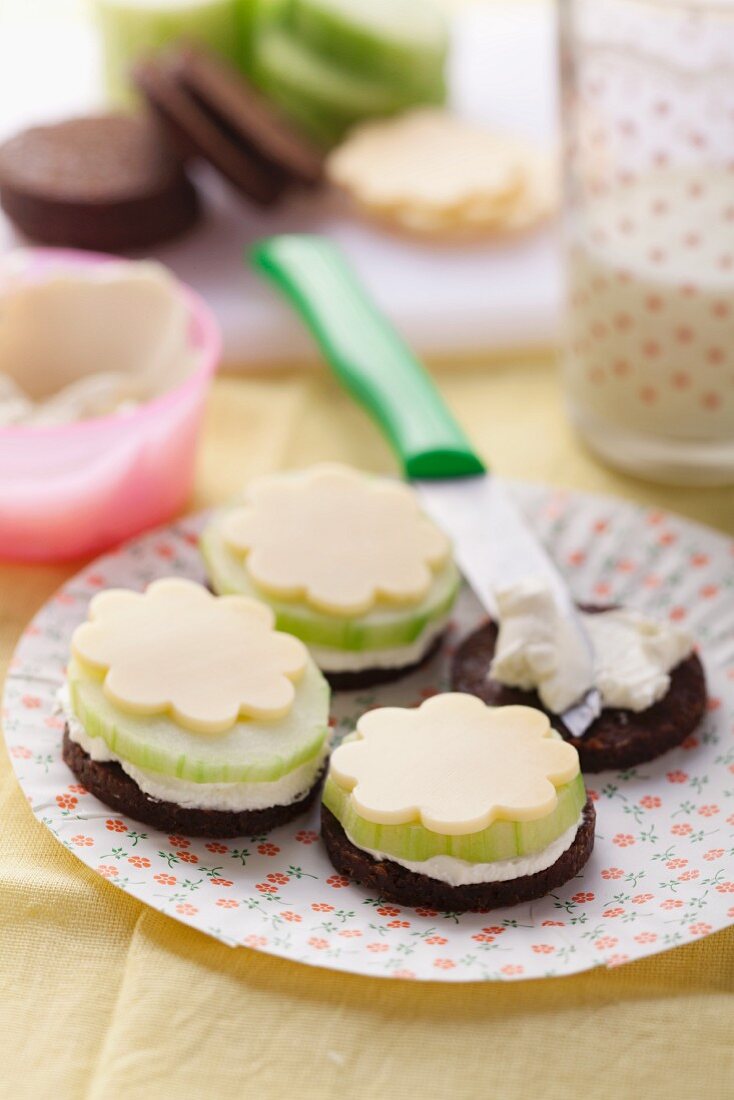 Pumpernickel rounds topped with cheese and cucumber