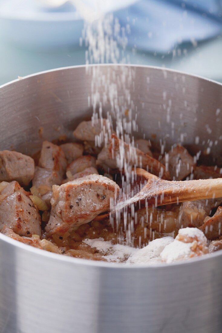 Angebratenes Kalbfleisch mit Mehl bestäuben