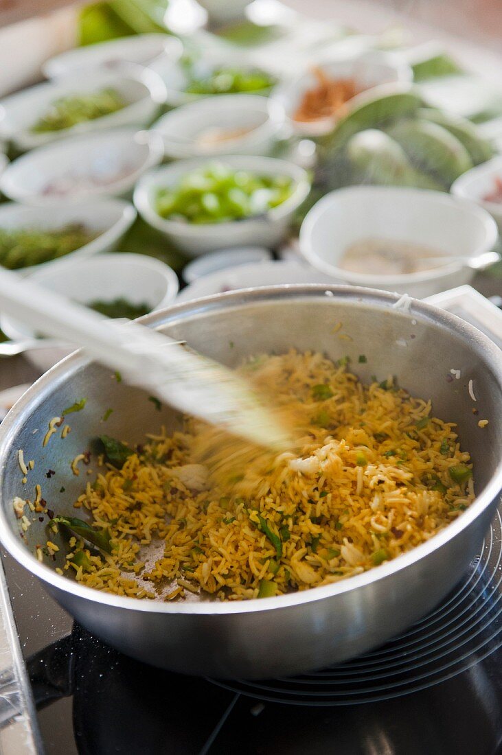 A rice dish with bowls of ingredients in the background (Mauritius)