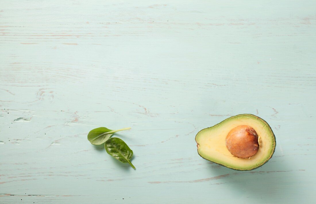 Avocadohälfte auf grünem Holz