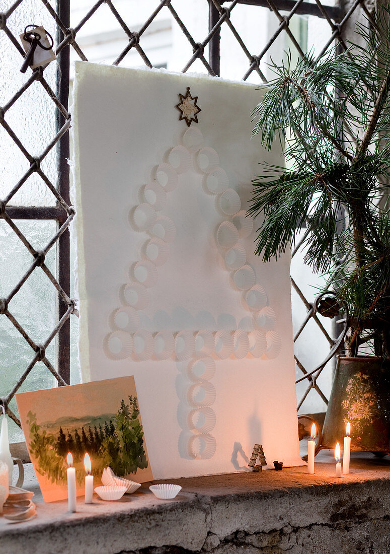 Tannenbaum aus weissen Pralinenförmchen auf Papierbogen