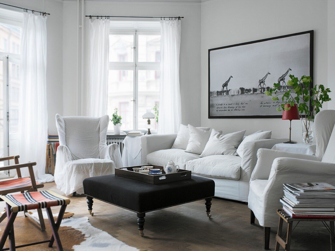 White, upholstered furniture and black coffee table