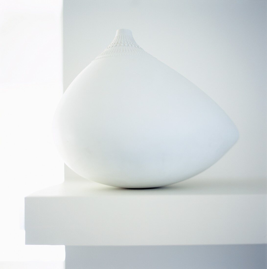 White ethnic vase on a shelf